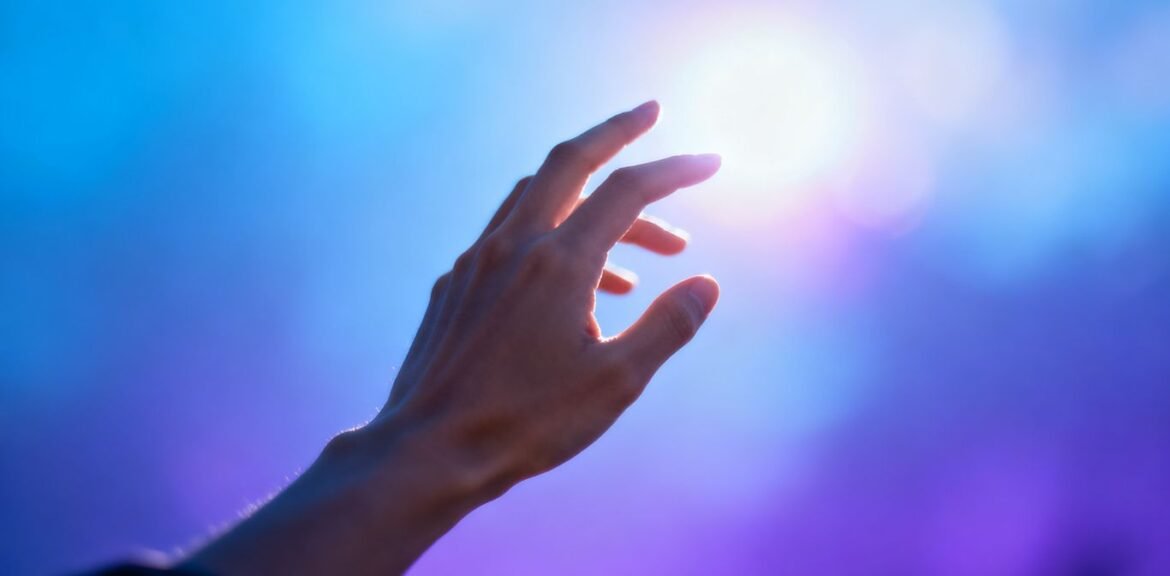 Main de personne atteignant une lumière brillante